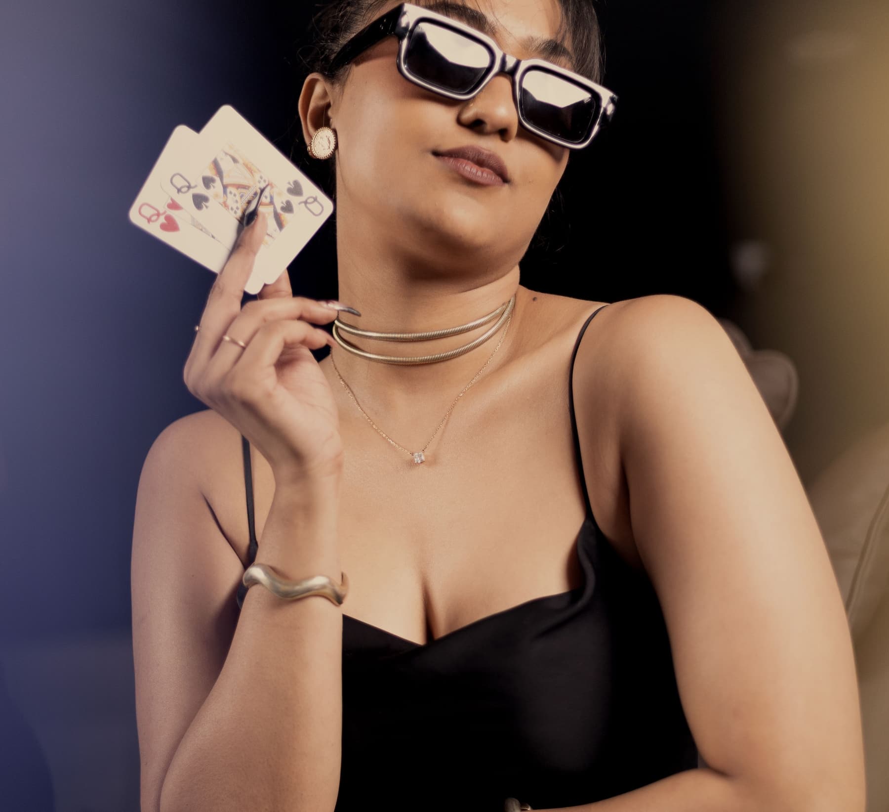 A player holding two cards up, chip stacks along the rail below.